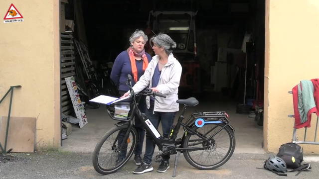 une personne montre comment fonctionne un vélo électrique à une autre